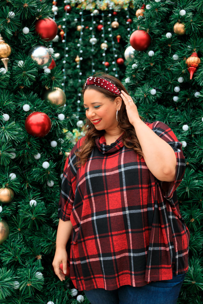 Plus size model in front of a christmas tree